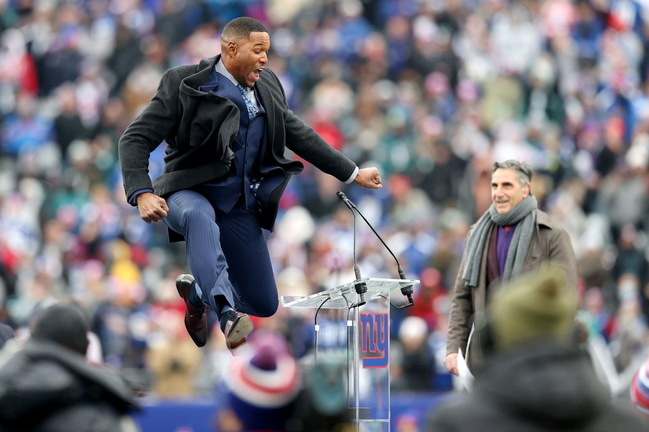 Hall of Fame football player Michael Strahan jumps in the air as the New York Giants retired his number on Sunday, November 28.