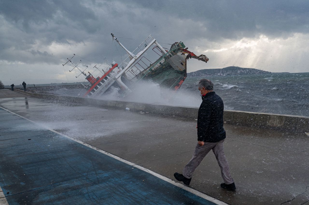 A man walks near a boat that had capsized due to <a href="https://www.cnn.com/2021/11/30/middleeast/turkey-fatal-wind-storms-november-2021-intl/index.html" target="_blank">strong winds in Istanbul</a> on Tuesday, November 30.