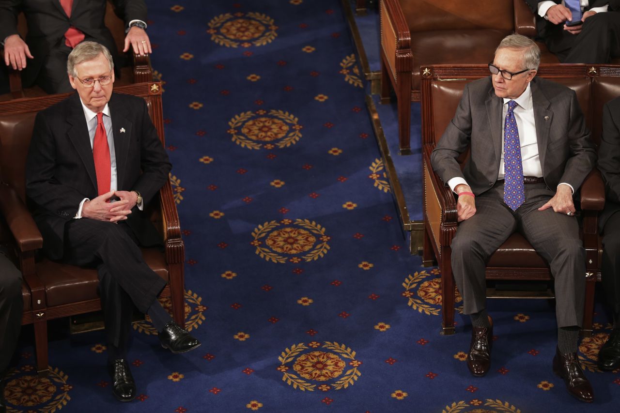 Reid and US Sen. Mitch McConnell sit across from each other inside the House chamber in 2015. Reid was minority leader at the time, and McConnell was majority leader.