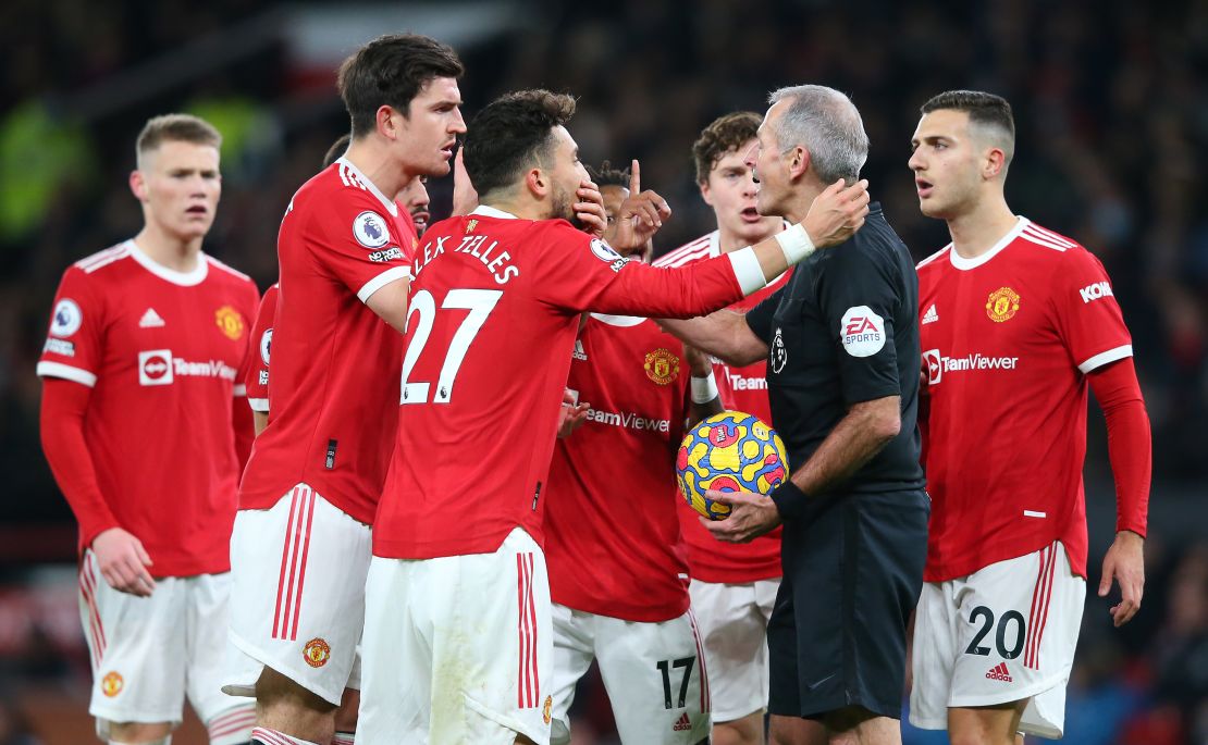 Manchester United players surround Martin Atkinson following the goal.