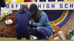 Mourners grieve at Oxford High School in Oxford, Mich., Wednesday, Dec. 1, 2021. A 15-year-old sophomore opened fire at Oxford High School, killing four students and wounding seven other people on Tuesday. Prosecutor says the parents of the Michigan high school shooting suspect are charged with crimes tied to deadly rampage.