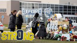 People gather at the memorial for the dead and wounded outside of Oxford High School in Oxford, Michigan on December 3, 2021. - The parents of a 15-year-old boy who shot dead four students at a high school in the US state of Michigan with a gun bought for him by his father just days earlier were charged with involuntary manslaughter. 