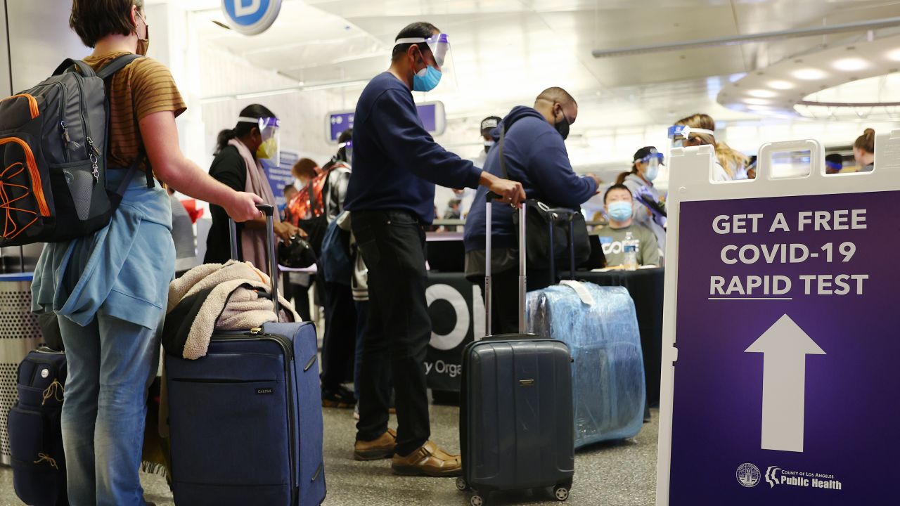 People who arrived on international flights wait to be tested on the first day of a new rapid COVID-19 testing site for arriving international passengers at Los Angeles International Airport (LAX) on December 3, 2021 in Los Angeles, California. The free voluntary tests are being offered to arriving passengers in the Tom Bradley International Terminal by the Los Angeles County Department of Health after the county confirmed its first case of the Omicron variant December 2.