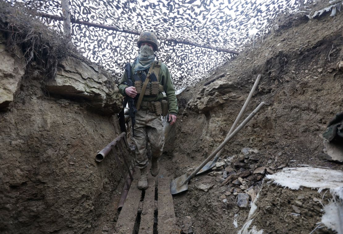 Ukrainian soldiers walk under a camouflage net in a trench on the line of separation from pro-Russian rebels near Debaltsevo, Donetsk region, in Ukraine on Friday.