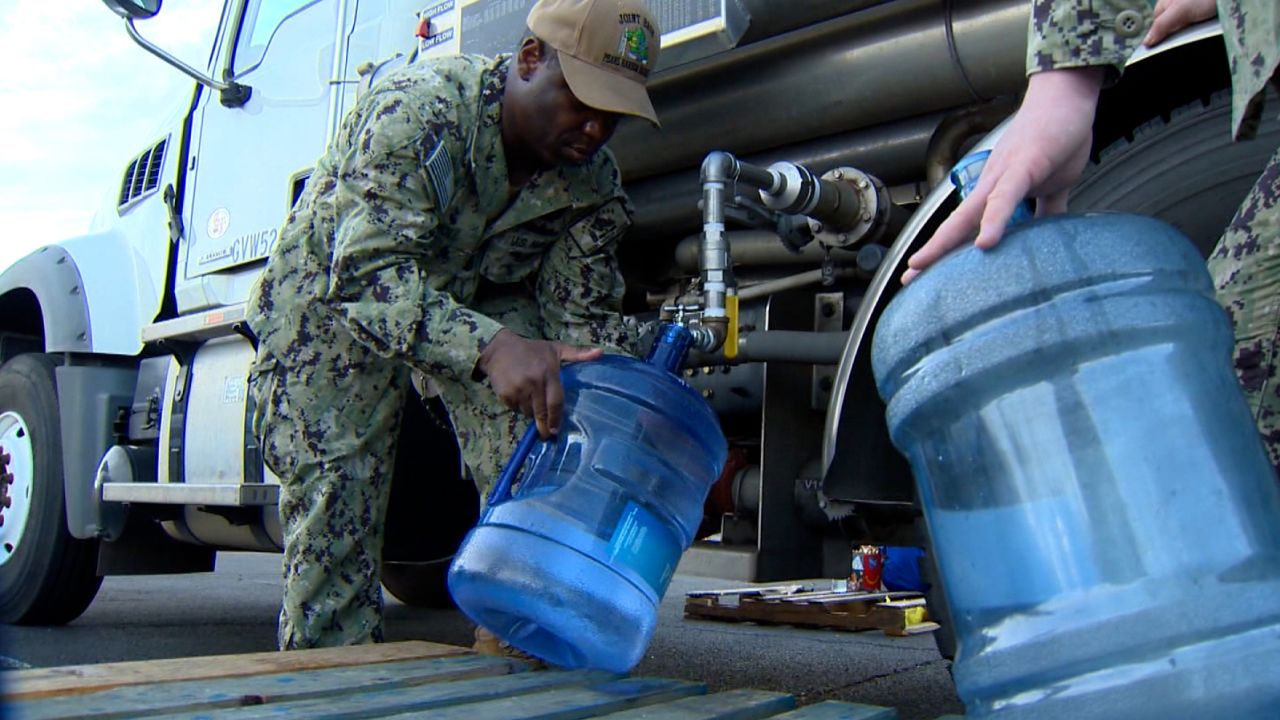 US Navy service members fill potable water for residents at the Navy Exchange Mall.