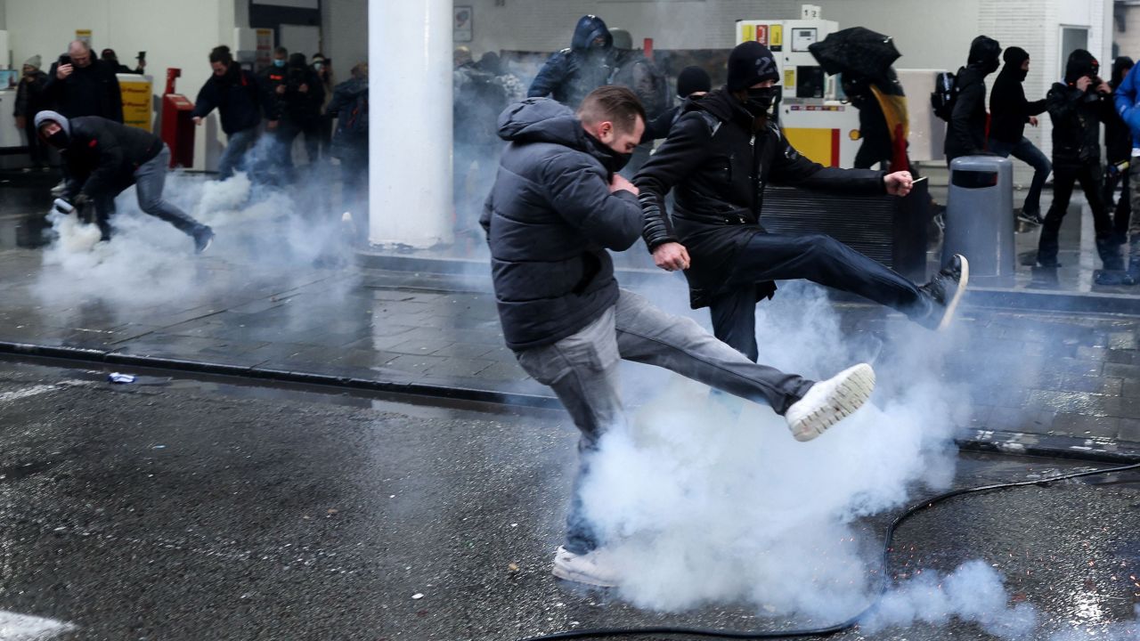 Protesters confront riot police during a demonstration against Covid-19 measures in Brussels, on december 5, 2021. 