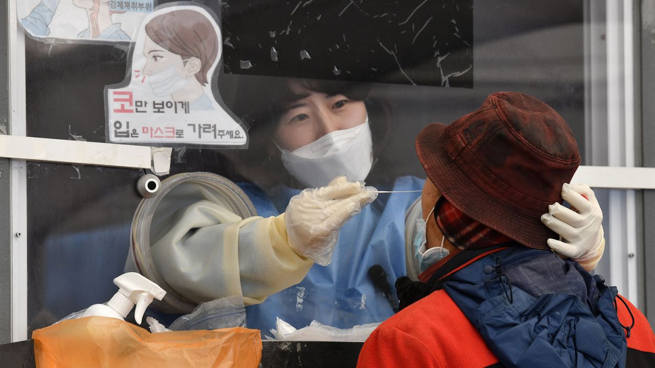 A medical staff takes a nasal swab from a visitor as part of a test for Covid-19 at a temporary testing centre in Seoul on December 1, amid growing concerns about the Omicron Covid-19 variant. 