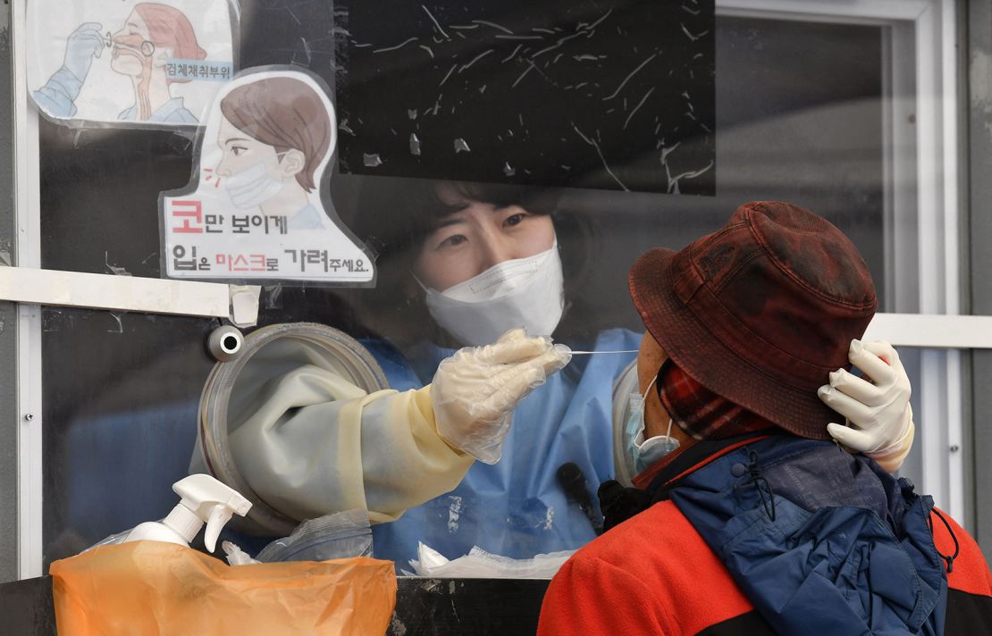 A medical staff takes a nasal swab from a visitor as part of a test for Covid-19 at a temporary testing centre in Seoul on December 1, amid growing concerns about the Omicron Covid-19 variant. 