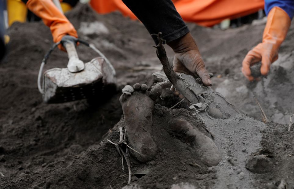 A victim's foot is uncovered by rescue workers on Monday.