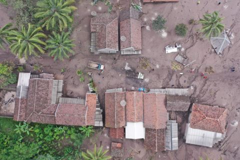 This aerial photo, taken on Monday, shows houses and trucks covered by ash in Sumberwuluh.