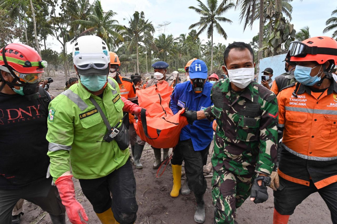 Members of a search-and-rescue team carry a dead body at the Sumberwuluh village on Monday.