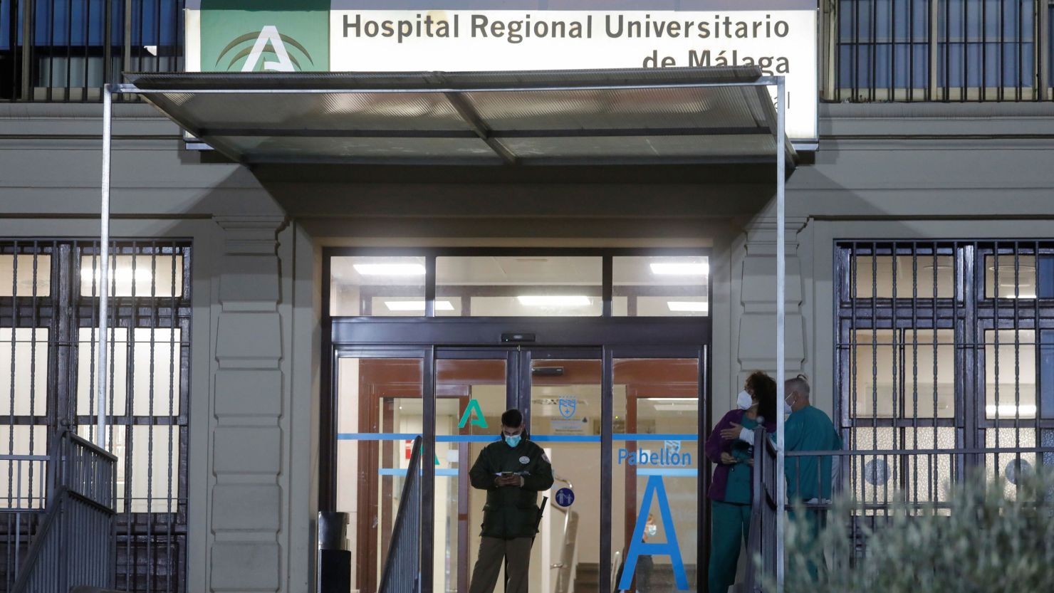 Healthcare workers stand at the front entrance of the Malaga Regional University Hospital, in Malaga, southern Spain, December 6, 2021.
