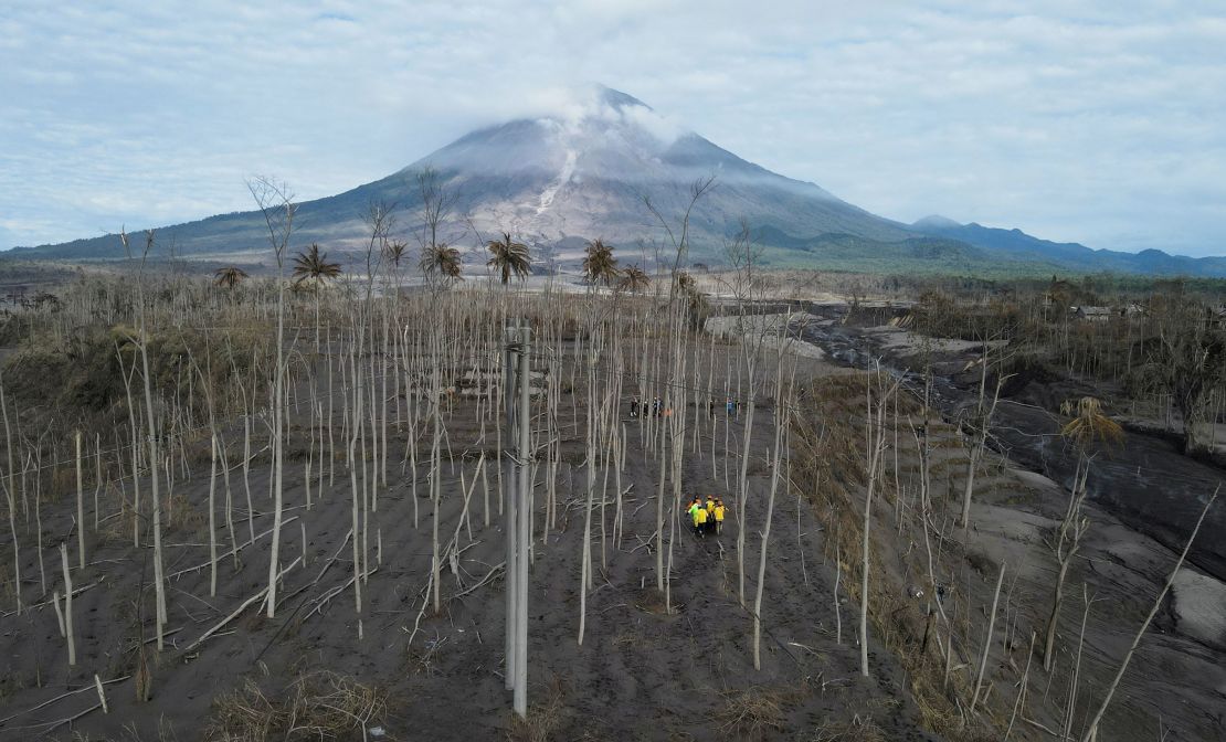 Rescue volunteers carry a body bag at an area affected by the eruption of Mount Semeru volcano in Lumajang, Indonesia, on December 7.