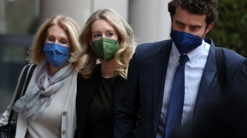 Theranos founder and former CEO Elizabeth Holmes (C) walks with her mother Noel Holmes (L) and her partner Billy Evans (R) as they arrive for her trial on Tuesday.