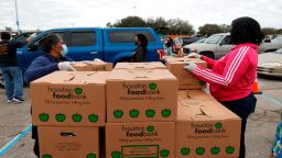 Volunteers prepare to load food into cars during the Houston Food Bank food distribution at NRG Stadium on February 21, 2021 in Houston.