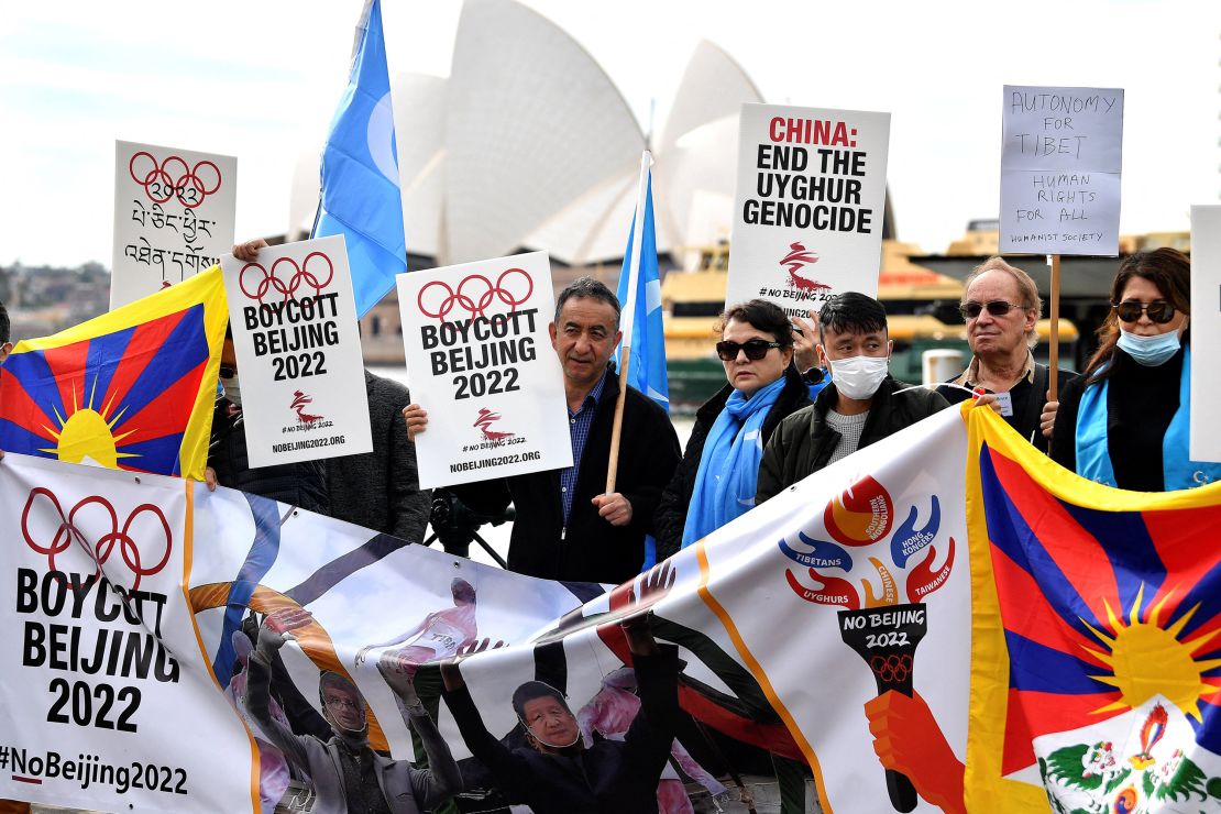 Protesters hold up placards and banners as they attend a demonstration in Sydney on June 23, 2021 to call on the Australian government to boycott the 2022 Beijing Winter Olympics over China's human rights record.