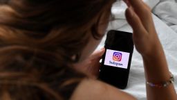 A person looks at a smart phone with a Instagram logo displayed on the screen, on August 17, 2021, in Arlington, Virginia. 