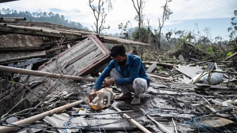 A man salvages some of his belongings from his damaged home in Lumajang on December 8.