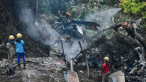 Firemen and rescue workers stand next to the debris of an IAF Mi-17V5 helicopter crash site in Coonoor, Tamil Nadu, on Wednesday.