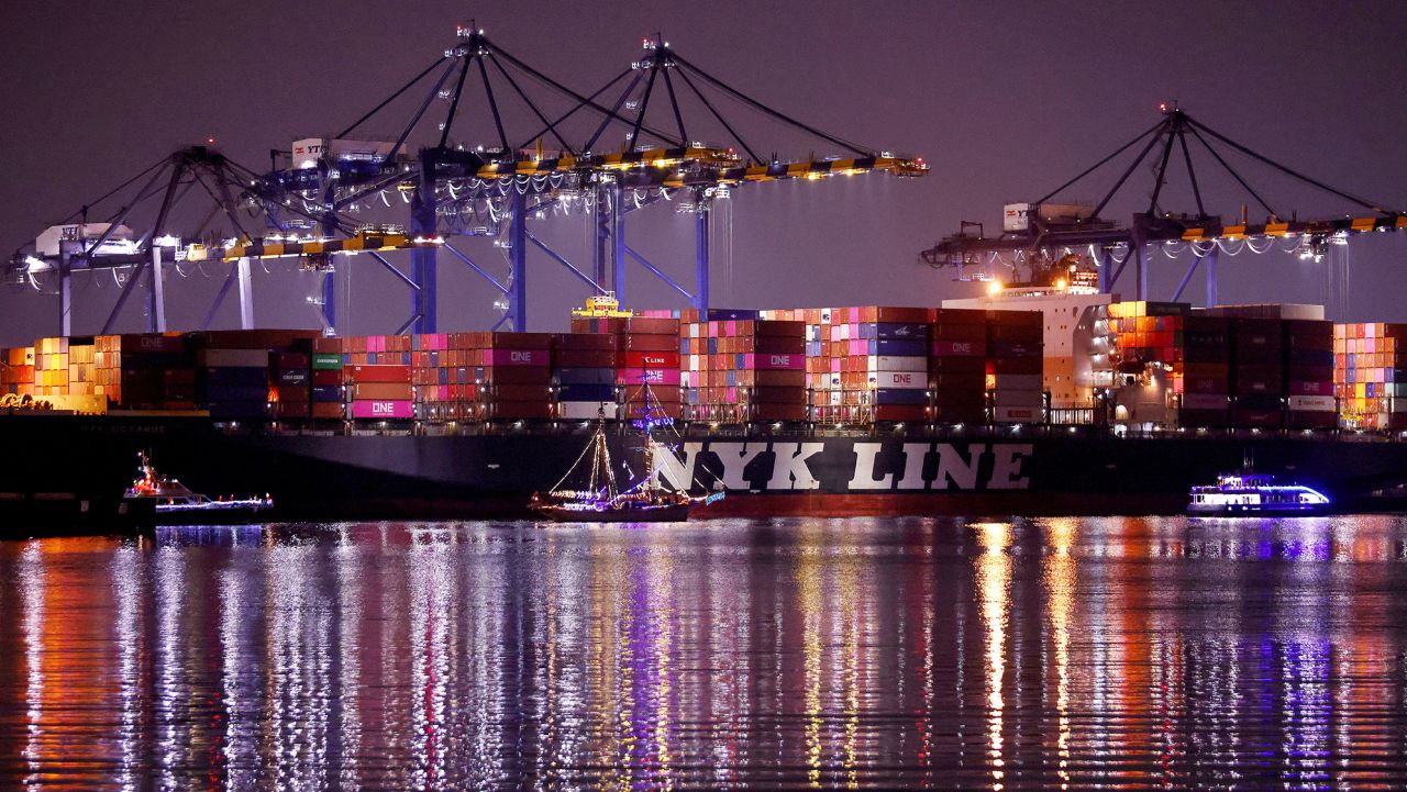 Holiday themed boats parade past a container ship loaded with shipping containers at the Port of Los Angeles during the 'Los Angeles Harbor Holiday Afloat Parade' on December 4, 2021 near San Pedro, California. The 59th annual boat parade marking the start of the holiday season featured boats of various sizes competing for awards. A backlog of aging cargo at the ports of Los Angeles and Long Beach has decreased 37 percent since last month amid continued supply chain disruptions.