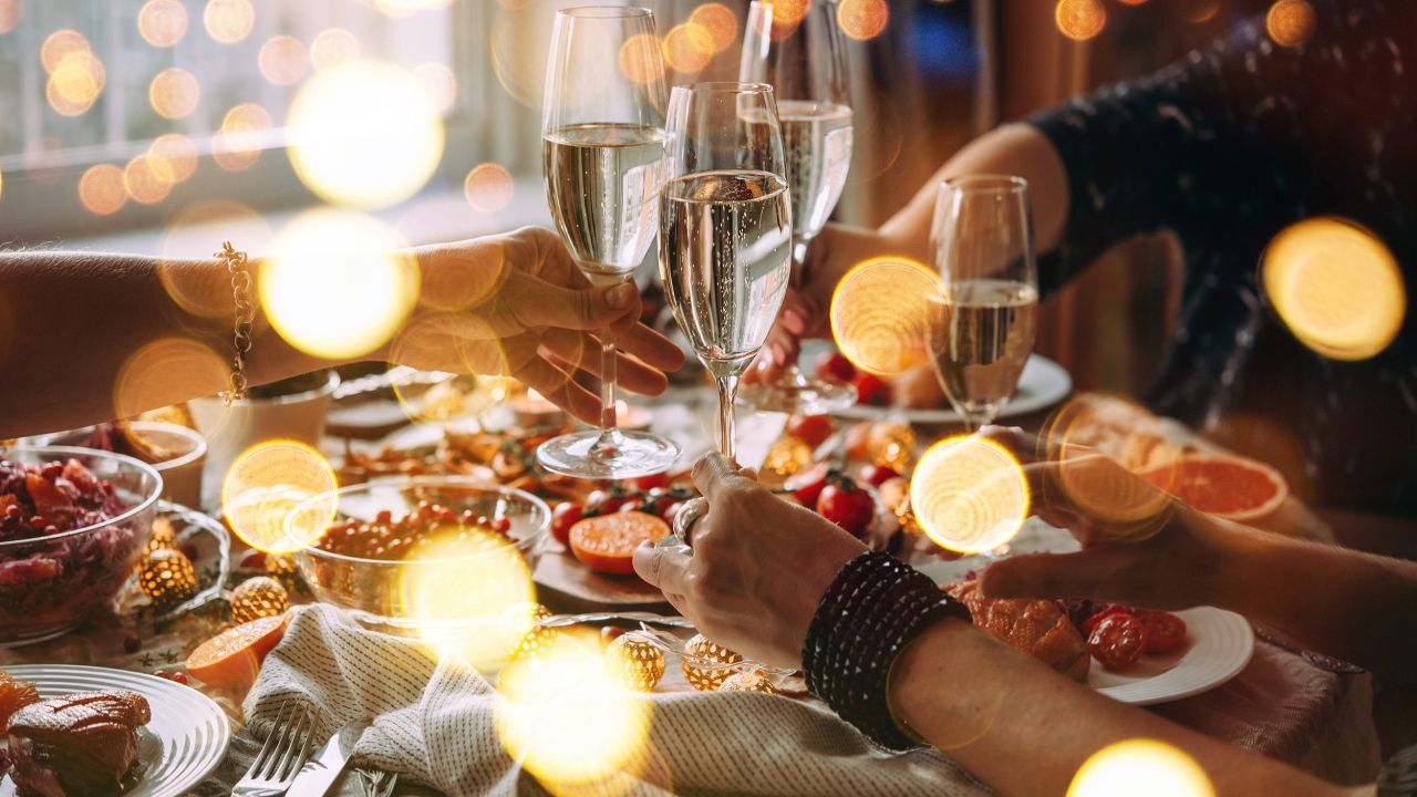 Party table with glasses of champagne. Friends celebrating Christmas or New Year eve.