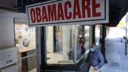 A pedestrian walks past the Leading Insurance Agency, which offers plans under the Affordable Care Act (also known as Obamacare) on January 28, 2021 in Miami, Florida. President Joe Biden signed an executive order to reopen the Affordable Care Act's federal insurance marketplaces from February 15 to May 15.