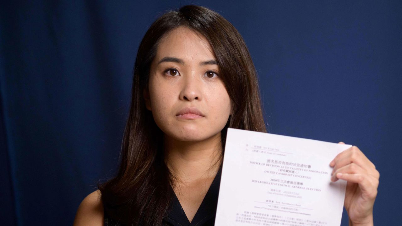 Pro-democracy activist Gwyneth Ho, who was banned from standing in upcoming local elections, poses with her disqualification notice at her office in Hong Kong on August 4, 2020. 