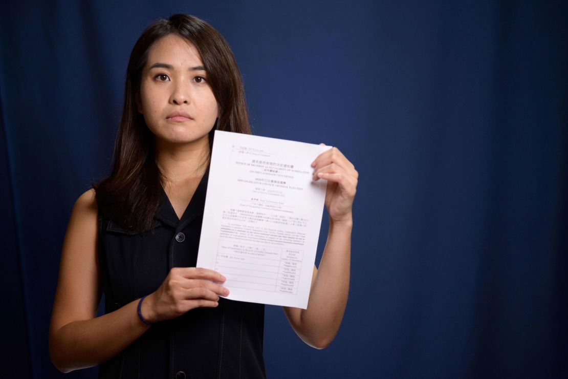 Pro-democracy activist Gwyneth Ho, who was banned from standing in upcoming local elections, poses with her disqualification notice at her office in Hong Kong on August 4, 2020. 