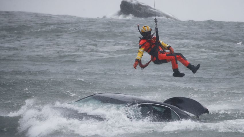 A U.S. Coast Guard diver is lowered from a hovering helicopter to pull a body from a submerged vehicle stuck in rushing rapids just yards from the brink of American Falls, one of three waterfalls that make up Niagara Falls, Wednesday, Dec. 8, 2021, in Niagara Falls, N.Y. (AP Photo/ Jeffrey T. Barnes)