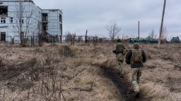 Ukrainian soldiers walk toward a destroyed building on the front line on December 8, 2021 in Marinka, Ukraine.