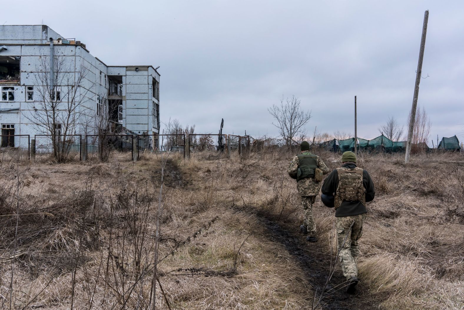 Ukrainian soldiers walk toward a destroyed building in Marinka on December 8.