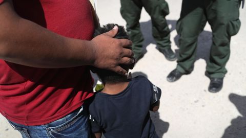 In this June 12, 2018, file photo, US Border Patrol agents take a father and son from Honduras into custody near the US-Mexico border outside Mission, Texas. The asylum seekers were then sent to a US Customs and Border Protection processing center for possible separation. 