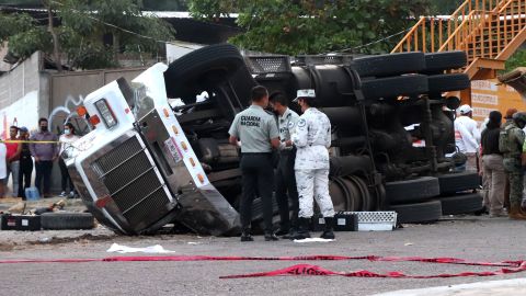 Mexican national guard officers work in the area where the truck rolled over.
