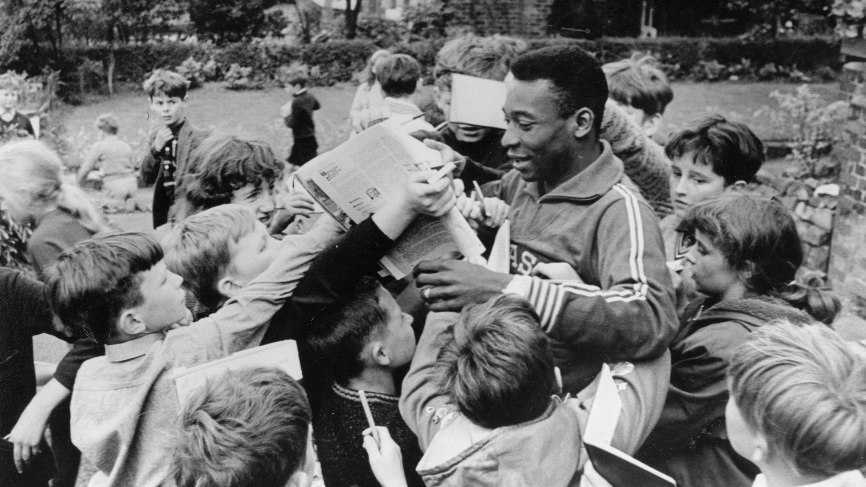 Pelé signs autographs for children in 1966. He played in the 1966 World Cup with Brazil but the team didn't advance out of the group stage that year.
