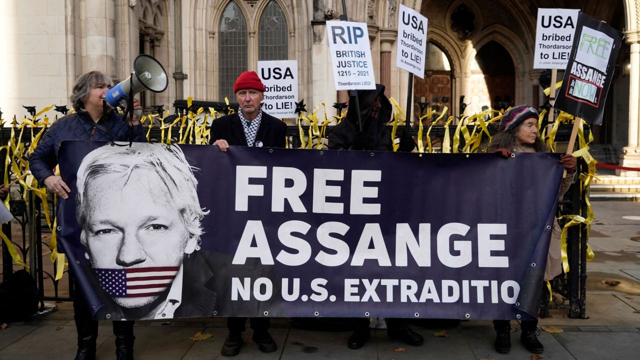 Supporters of WikiLeaks founder Julian Assange hold placards outside the Royal Courts of Justice in London on December 10, 2021.