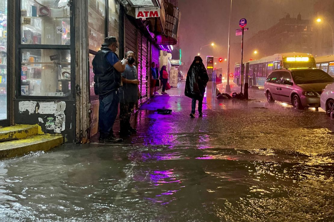 New Yorkers wade through flooded streets brought by extreme rainfall from the remnants of Hurricane Ida on September 2021, in the Bronx borough of New York City. 