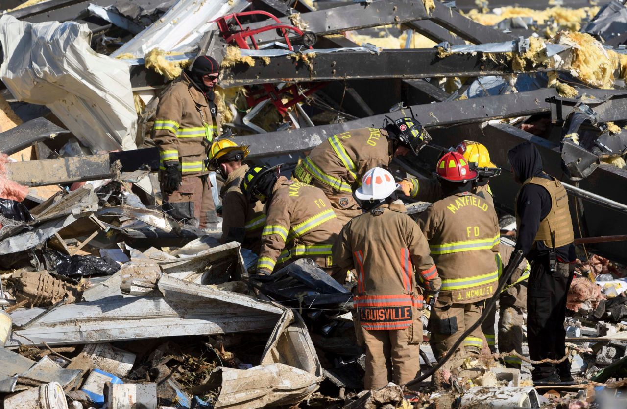 Emergency workers search through what is left of the Mayfield Consumer Products candle factory.