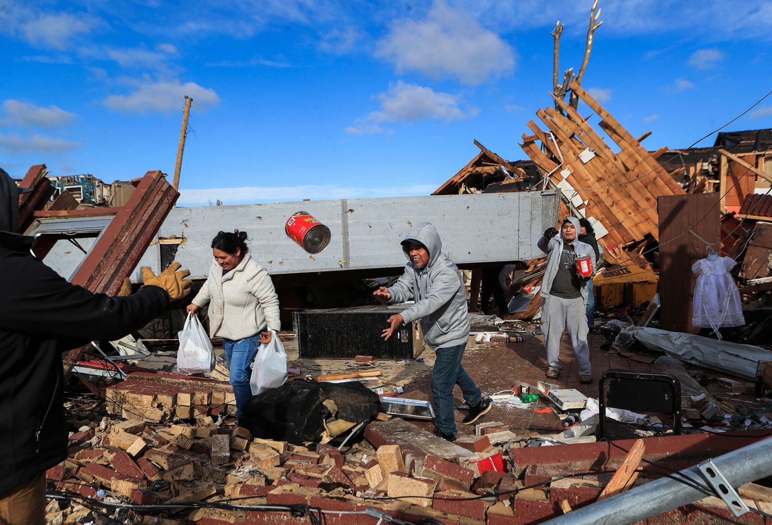 Employees and friends of La Azteca try to salvage food items after the eatery was destroyed in downtown Mayfield.