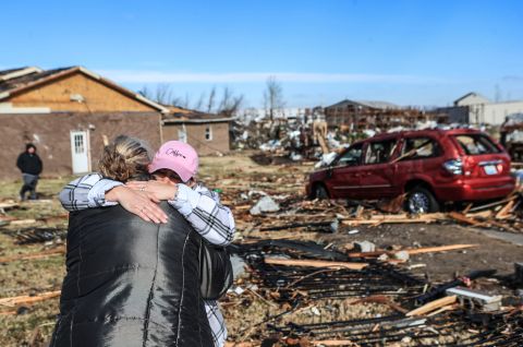 Irene Noltner, in a pink hat, consoles Jody O'Neill outside The Lighthouse, a women and children's shelter that was destroyed in Mayfield.