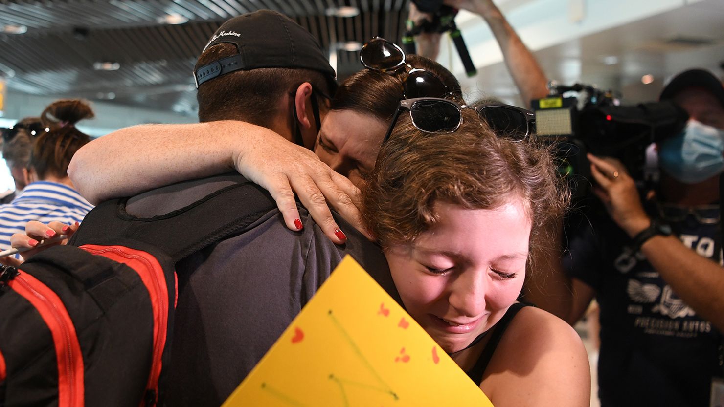 A family reunites at Brisbane's domestic terminal after the first flight from Melbourne since border restrictions have eased on December 13.