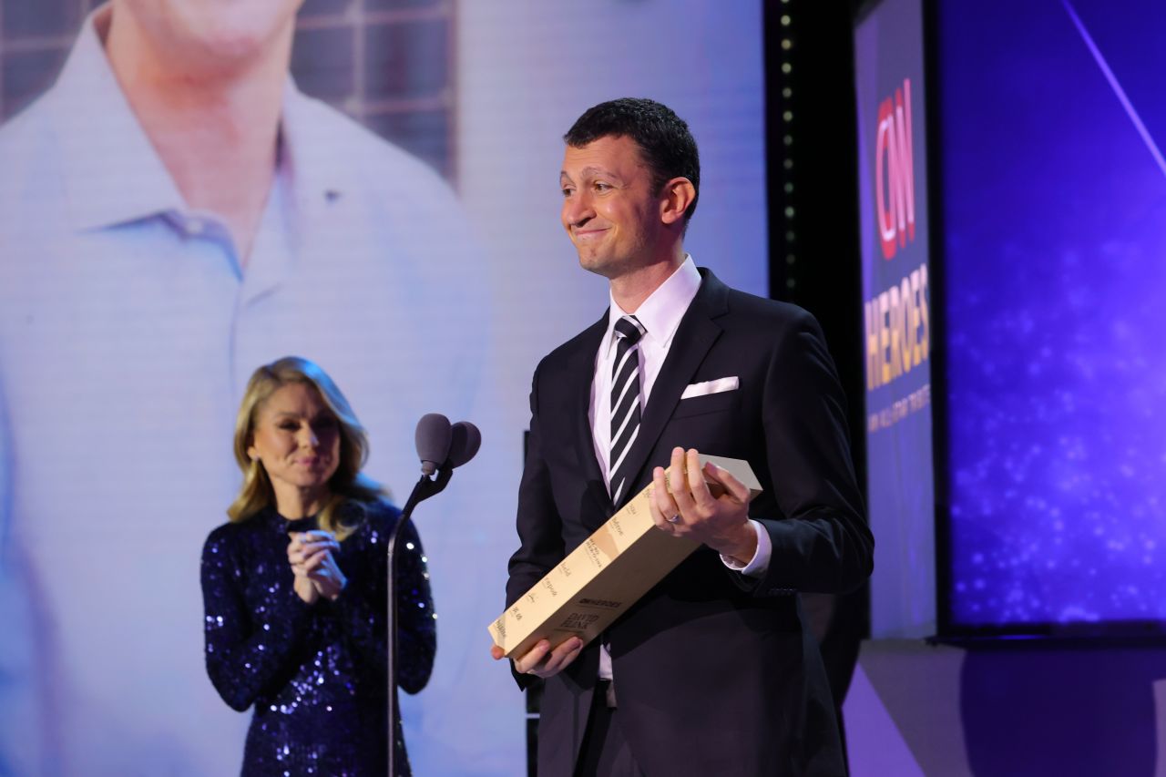 2021 CNN Hero David Flink accepts his award onstage from Kelly Ripa. Since 1998, <a href="https://eyetoeyenational.org/" target="_blank" target="_blank">Eye to Eye</a> has grown into a nationwide non-profit that pairs middle school children who have a learning difference with a college or high school mentor who also has a learning difference.