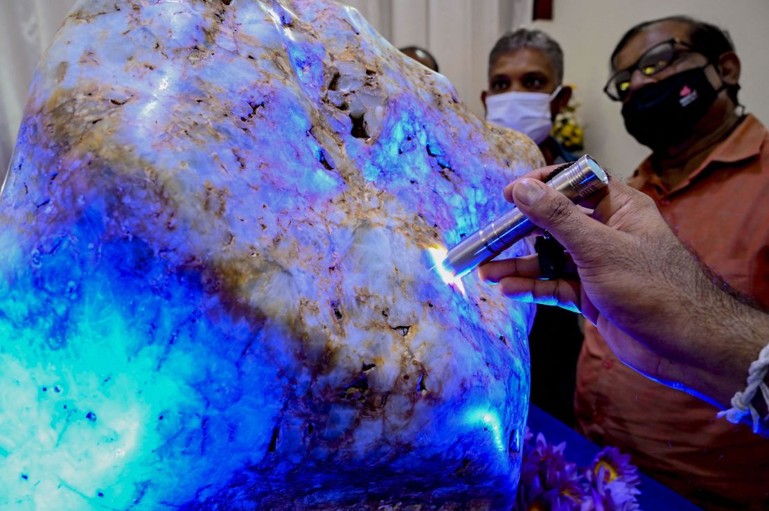 People inspect the blue sapphire, dubbed "Queen of Asia," in Horana, Sri Lanka.