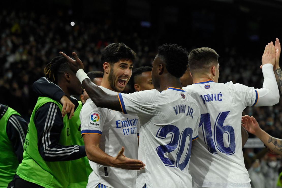 Marco Asensio celebrates with teammates after scoring the game's second goal. 