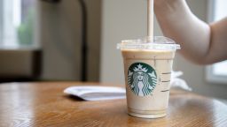 A customer is using a paper straw to drink a cold Starbucks latte in Tianjin, China, in July 2021.
