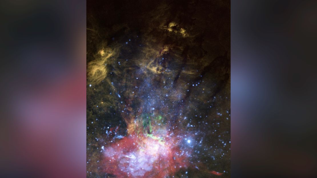 This composite of view shows X-rays and warm, energetic gas near the center of the Milky Way galaxy. Glowing hydrogen gas is revealed in orange and streams show where a jet from the central black hole pushed through.