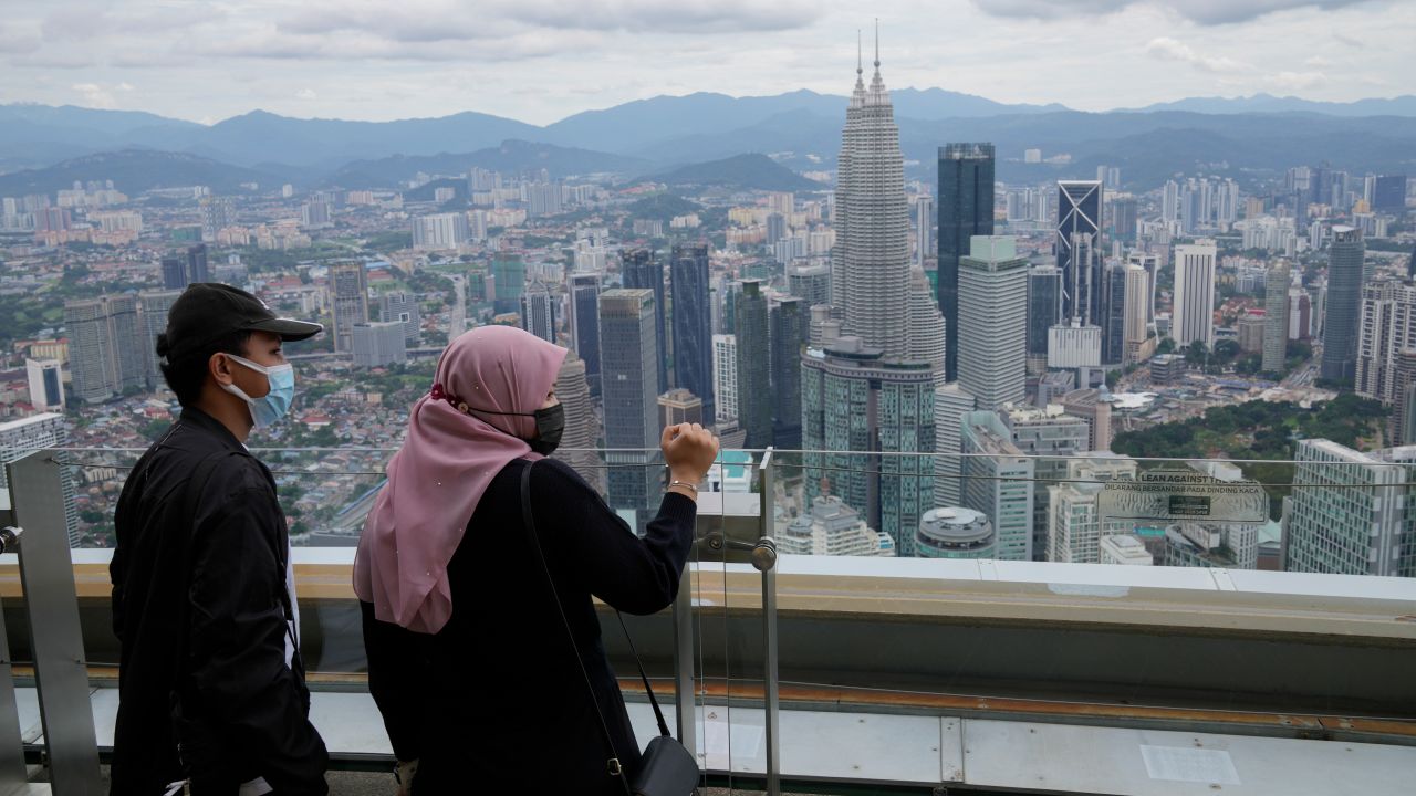 Tourists wearing face masks view from an observation deck at the Kuala Lumpur Tower in Kuala Lumpur, Malaysia.