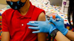 A child receives a dose of the Pfizer-BioNTech COVID-19 vaccine at an elementary school vaccination site for children ages 5 to 11-year-old in Miami, Florida, U.S., on Monday, Nov. 22, 2021. Florida Governor Ron DeSantis signed legislation that would restrict Covid vaccine mandates by employers. Photographer: Eva Marie Uzcategui/Bloomberg via Getty Images