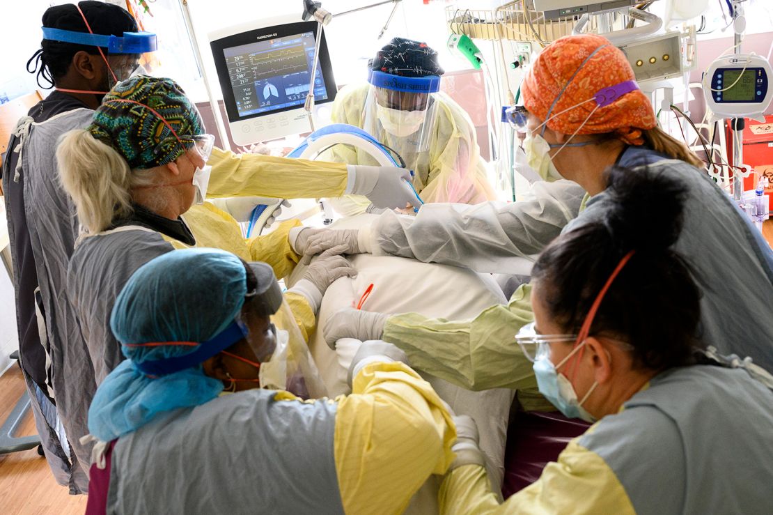  Respiratory therapist Spirya Andrews, back center, works with a critical care team on a critically ill Covid-19  patient on Wednesday, Dec. 8, 2021, at North Memorial Health Hospital in Robbinsdale.