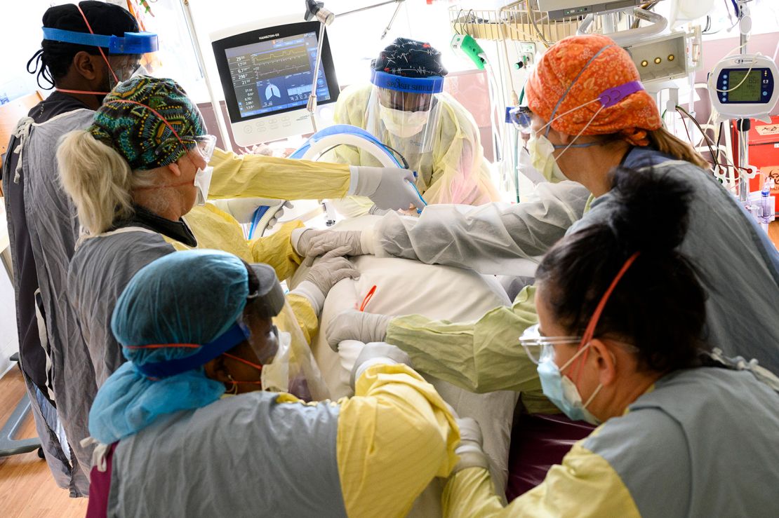 Respiratory therapist Spirya Andrews, back center, works with a critical care team on a critically ill Covid-19 patient on Wednesday, Dec. 8, 2021, at North Memorial Health Hospital in Robbinsdale.