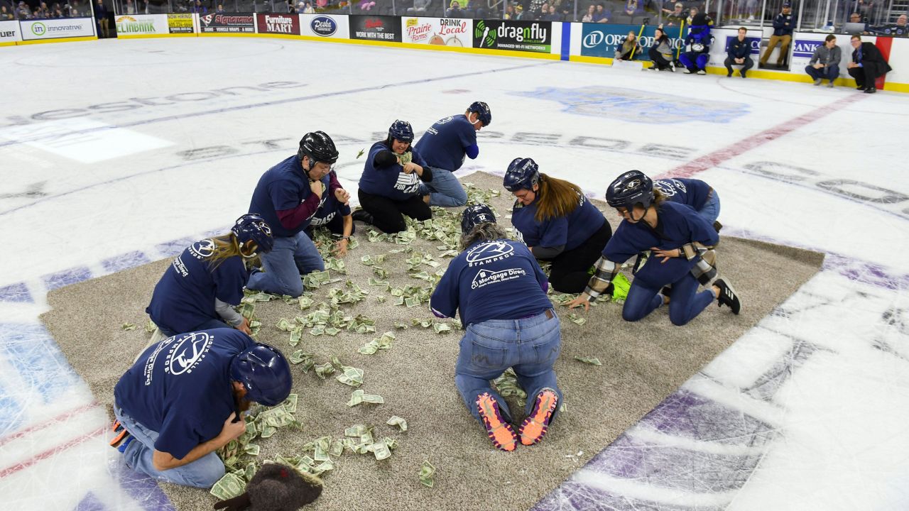 Teachers in Sioux Falls scramble for dollar bills to fund projects for their classrooms. Critics said the stunt was demeaning.